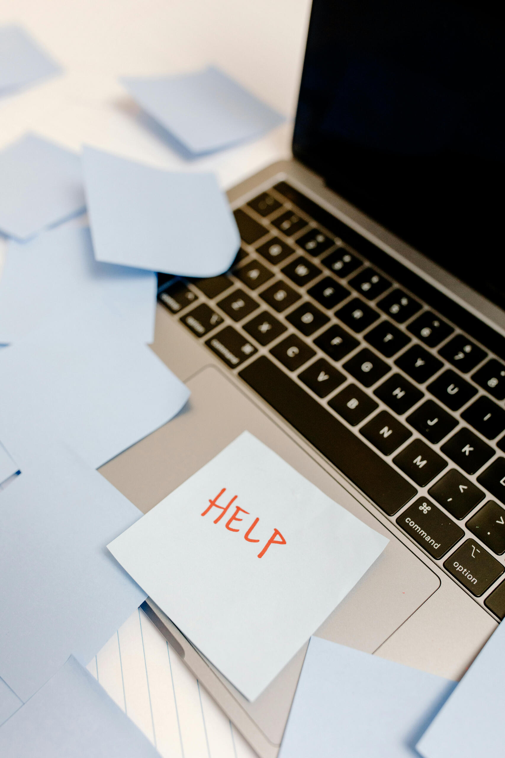 Technology frustration and digital overwhelm Laptop covered with sticky notes, including one that says “HELP,” symbolizing the confusion and frustration people feel with technology before Brasstown Consulting helps them build digital confidence